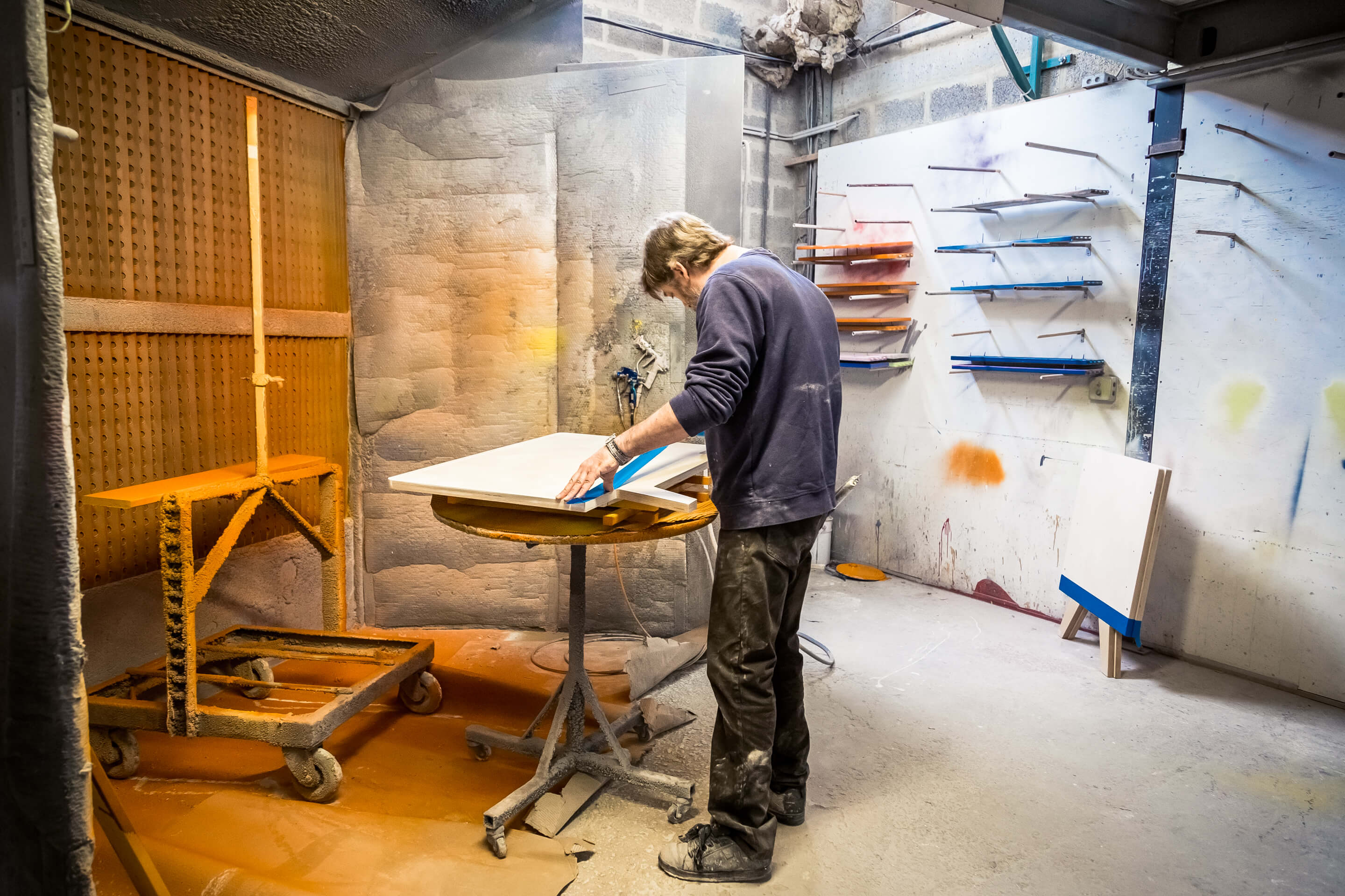artisan preparant une structure en bois avant finition en atelier